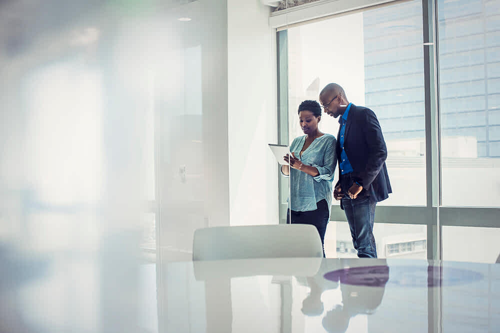 A women showing something on tablet to a men