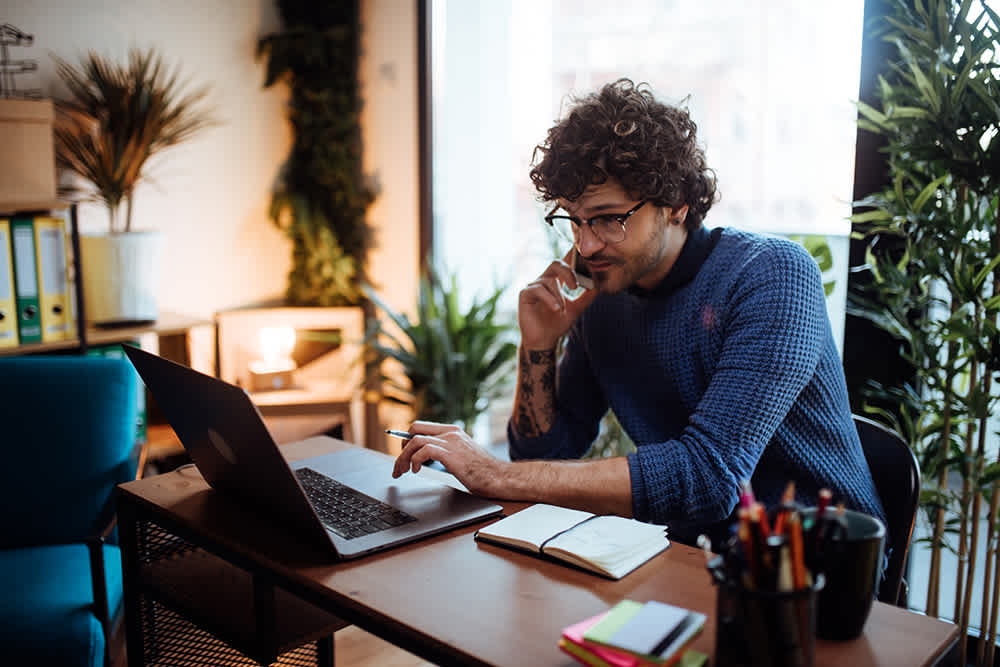 Man in blue shirt working on laptop
