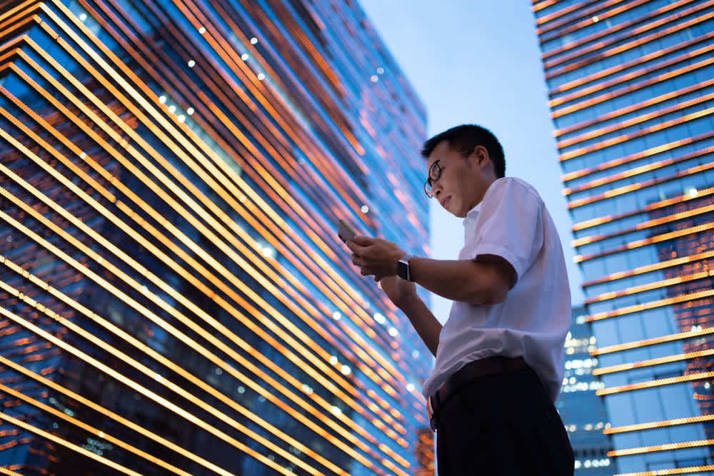 man on phone in front of buildings 