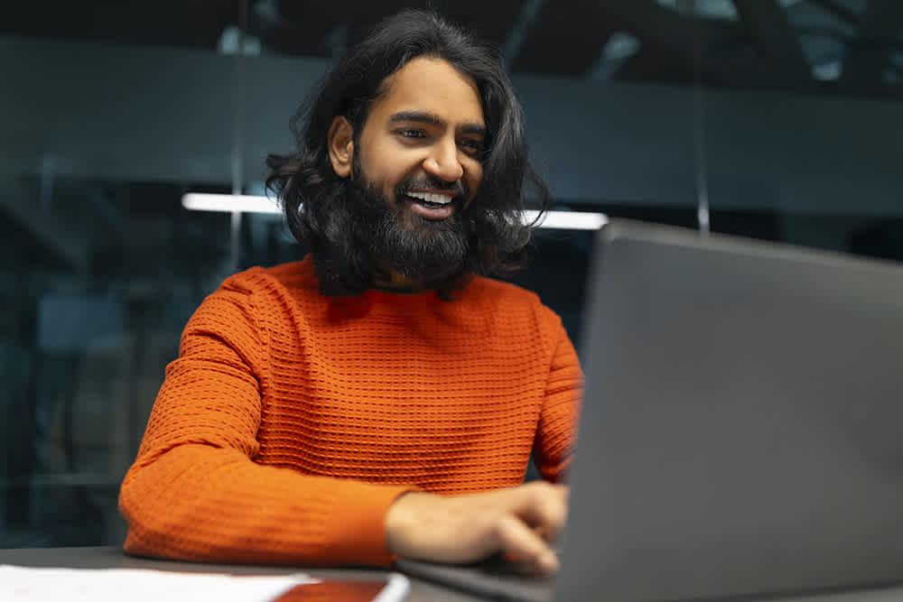 A happy man working on a laptop