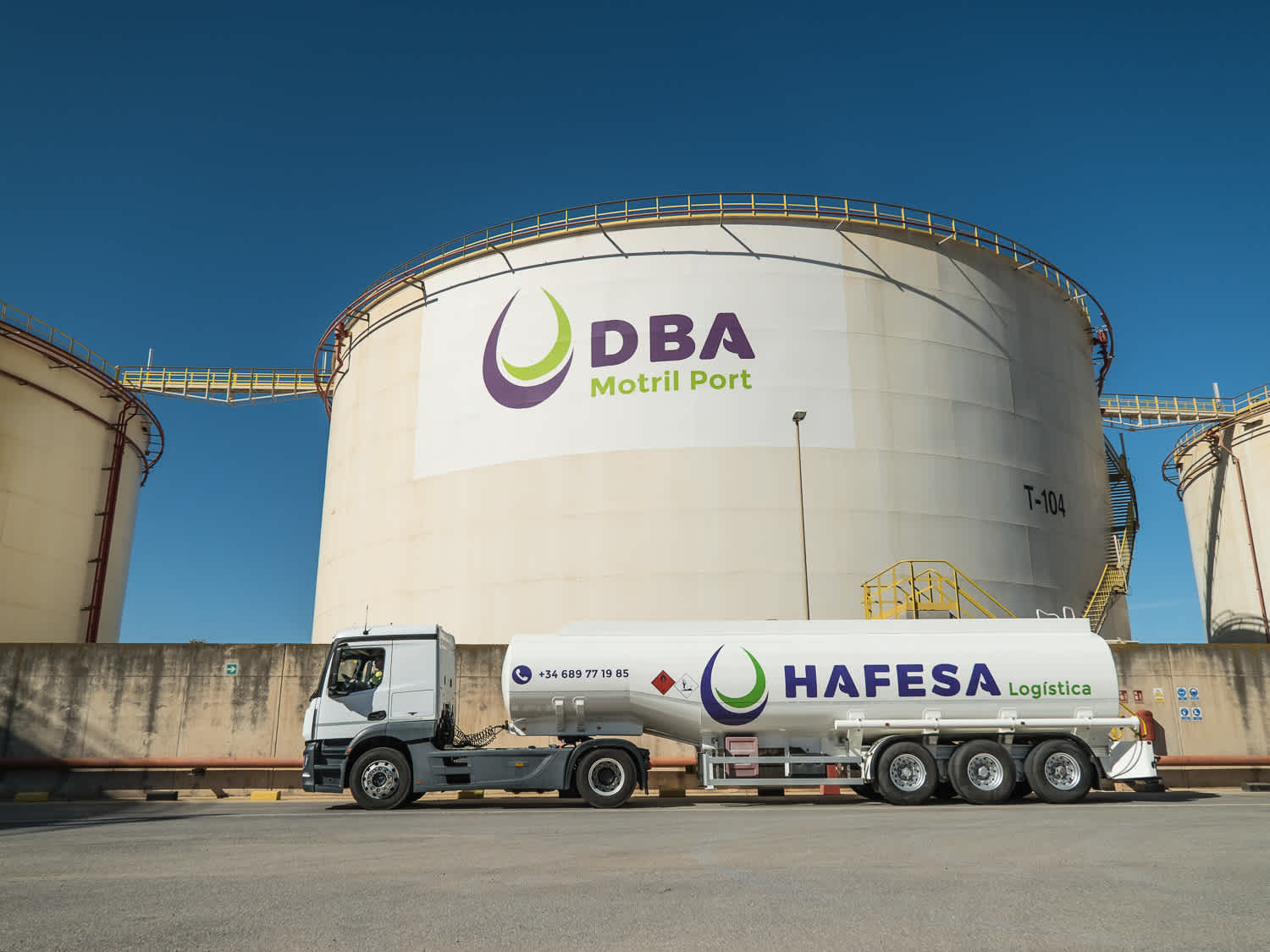 Hafesa Logistics commercial haul vehicle featured in front of large cylindrical DBA Motril-Port structure. 