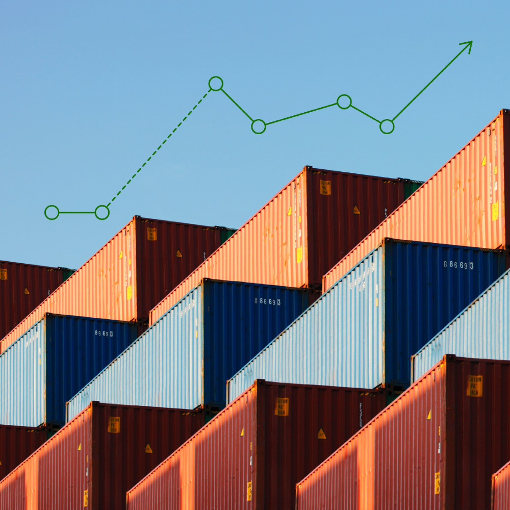 Stacked shipping containers with a green upward trend line chart overlay against a clear sky