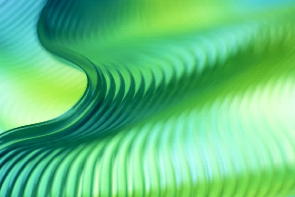 Abstract image of flowing, wavy lines in green and blue shades, creating a smooth, rippling pattern. The design gives a sense of movement, depth, and fluidity with soft lighting and gradient colors.