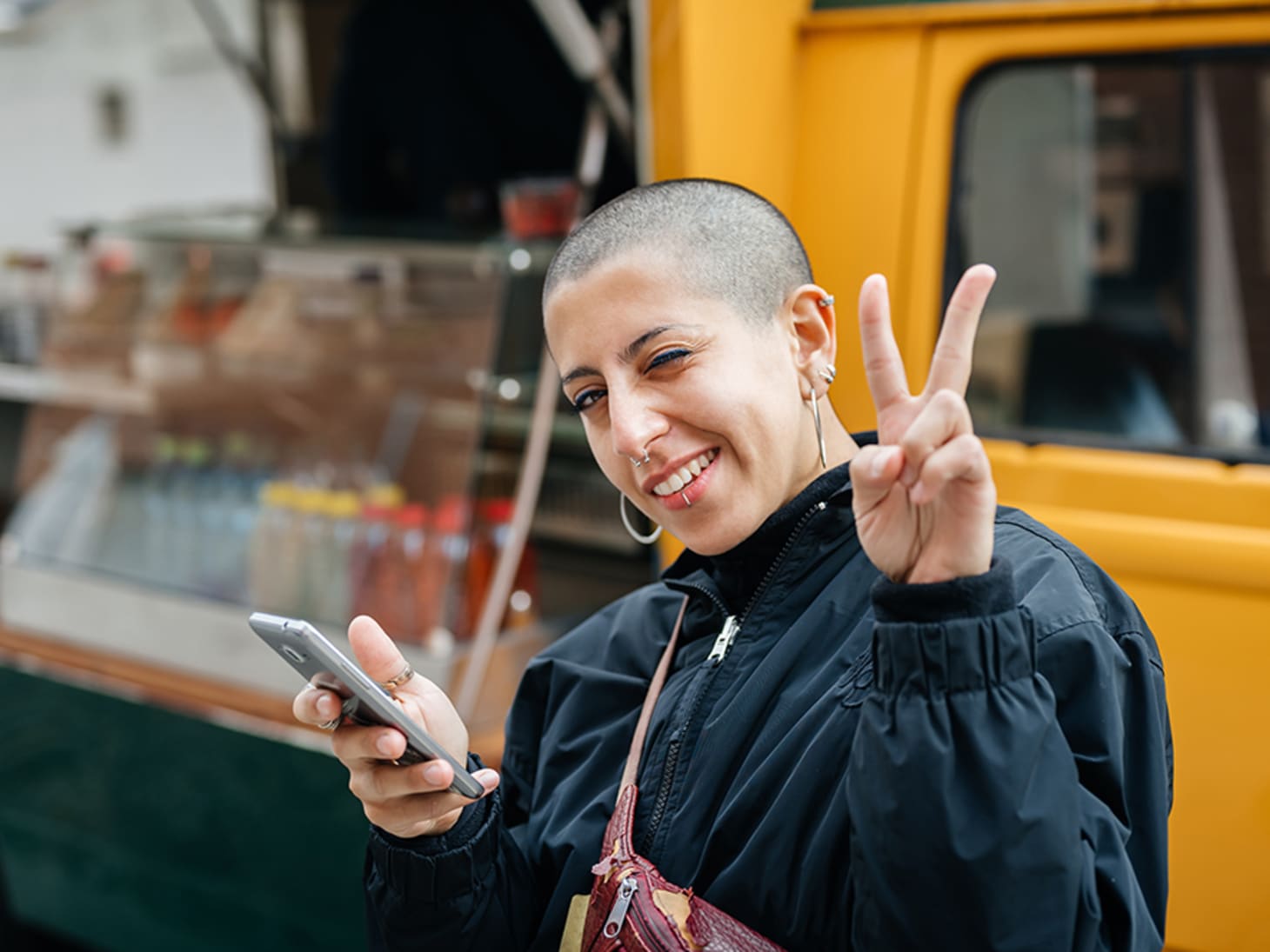 woman with shaved head flashing peace sign