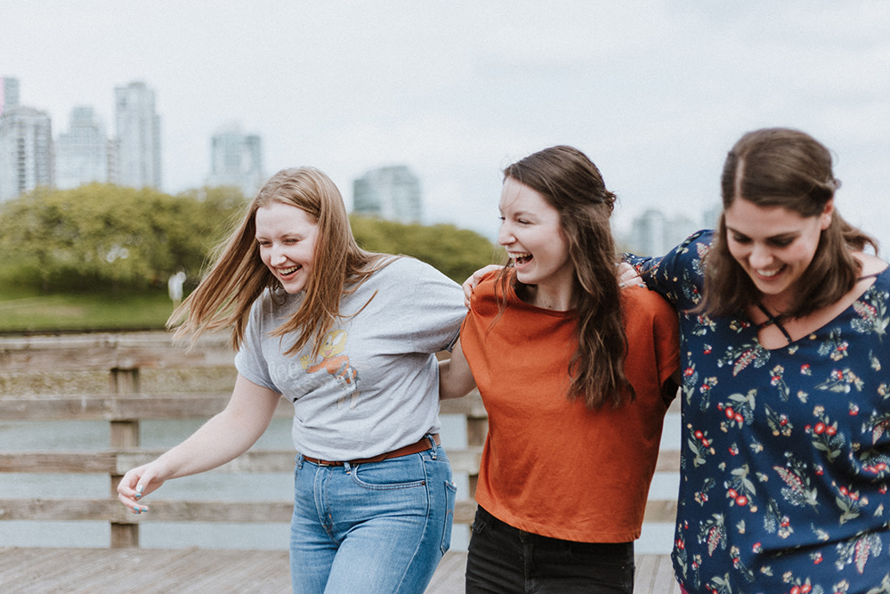 three woman walking arm in arm