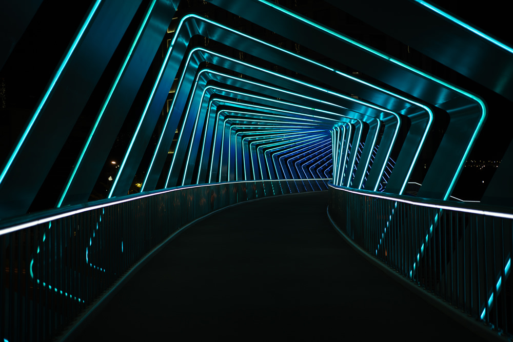 black tunnel framed by neon blue arched lights