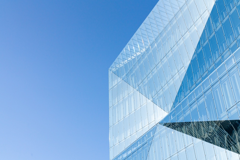 geometric glass building against blue sky