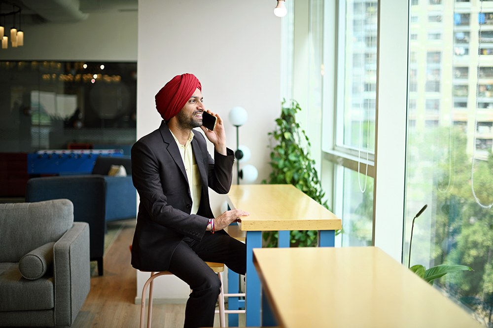 Indian man in suit and turban working by the window