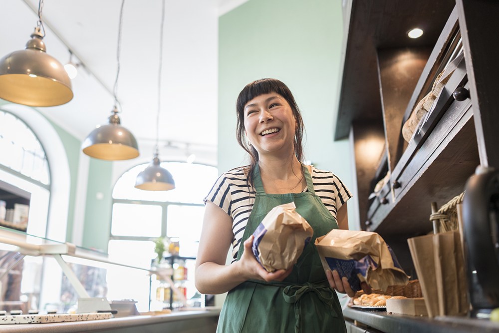 woman working in a bakery, serving bread