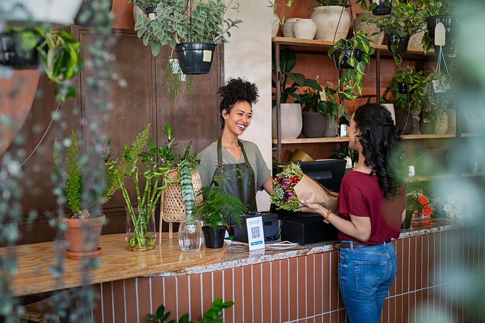 woman checking out at plant store with the female shop owner