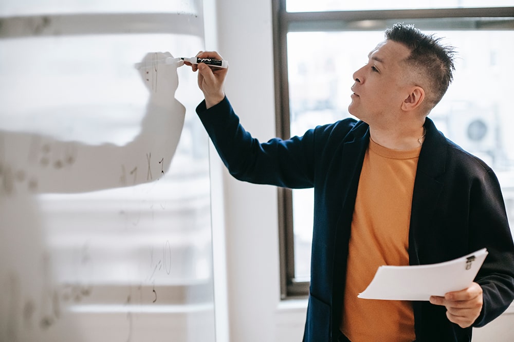 man writing on whiteboard