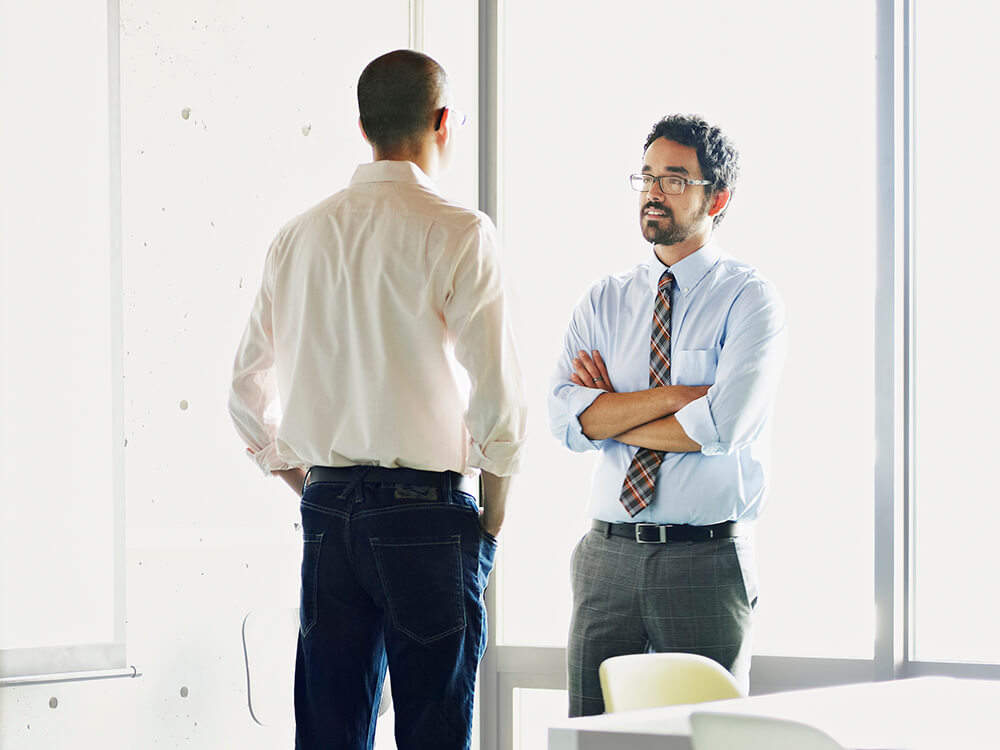 two male coworkers in discussion at office