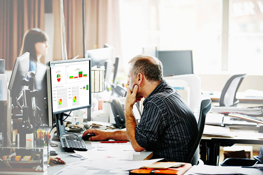 Man working on his desk at work with NAVEX IRM on his screen