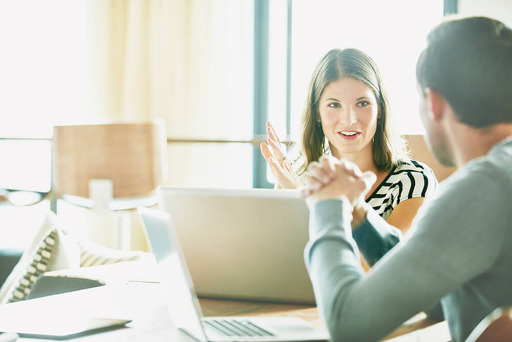 woman and man working together at their laptops 