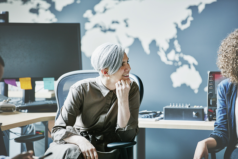 gray-haired male leaning in to listen to coworker