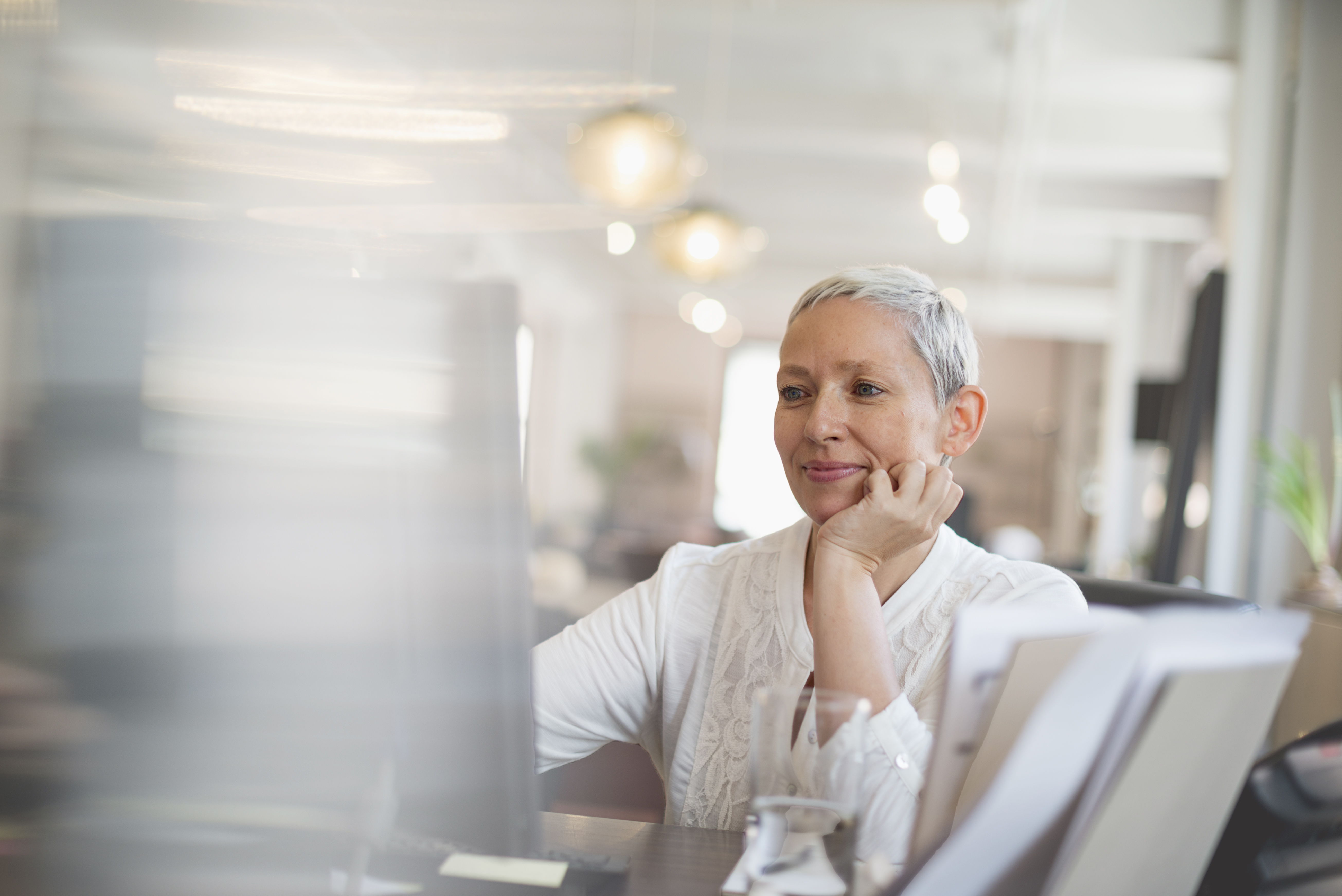 professional working woman with short gray hair looking at computer screen