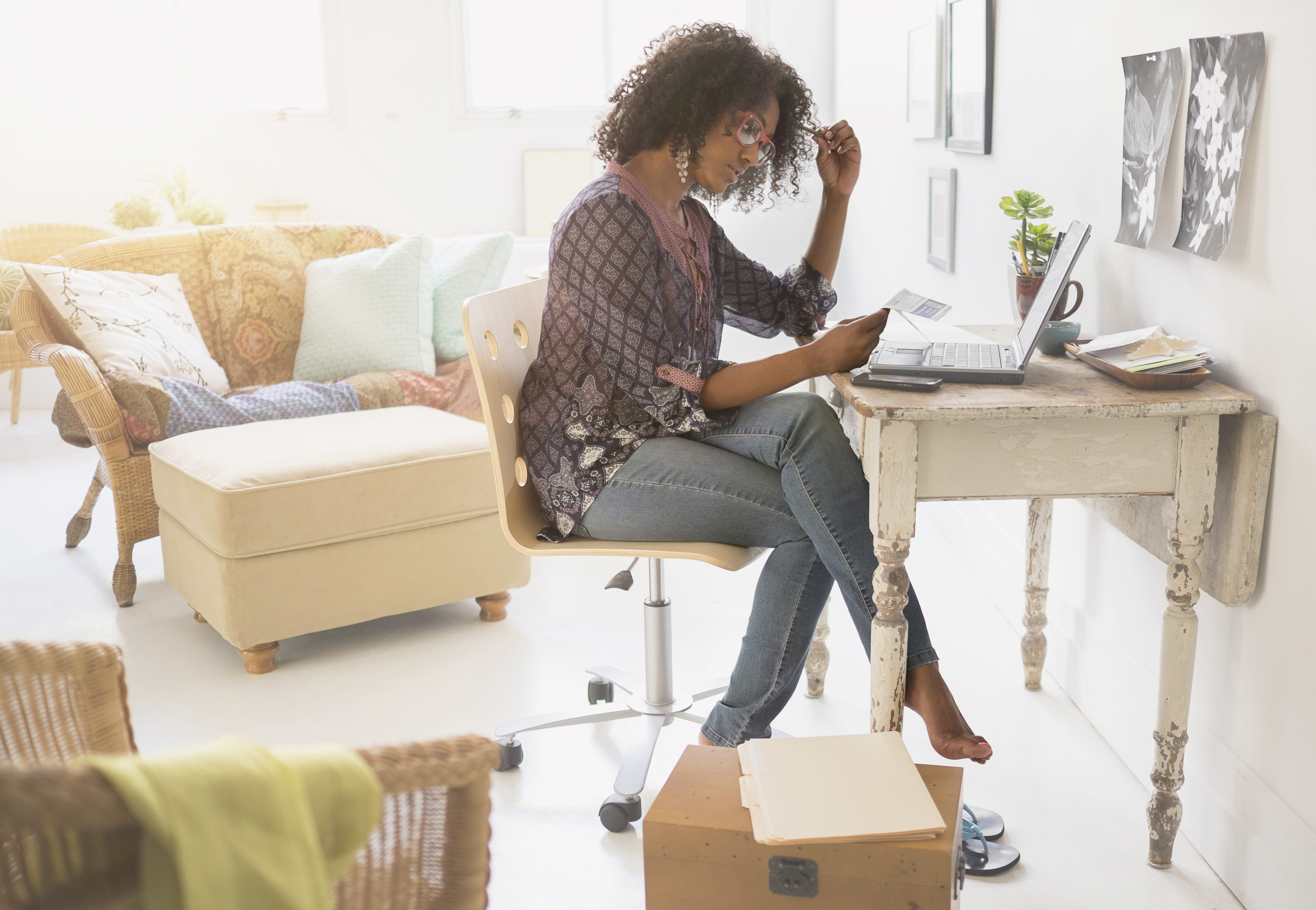 black woman working at home desk shoeless