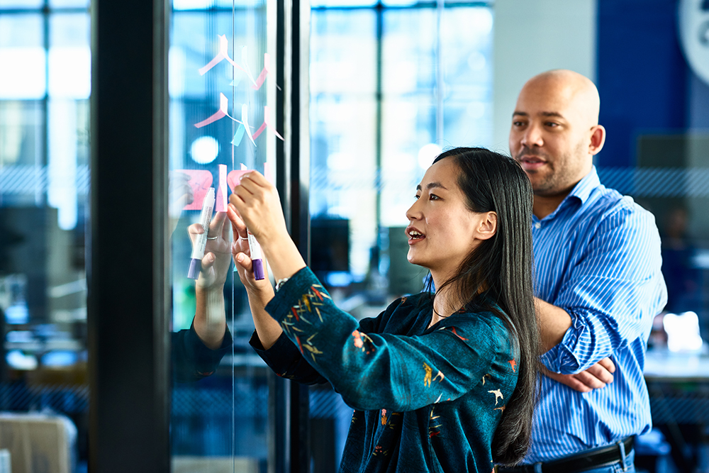 two coworkers brainstorming with post-its 