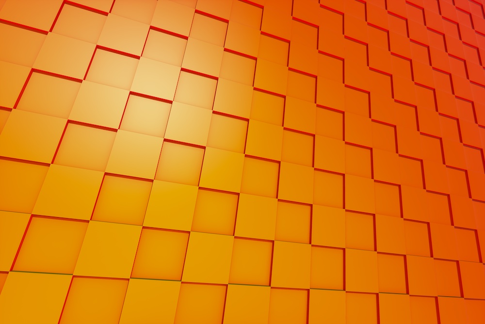 A geometric pattern of orange and yellow square tiles arranged in a diagonal, overlapping grid, creating a three-dimensional effect with varying shades and lighting.