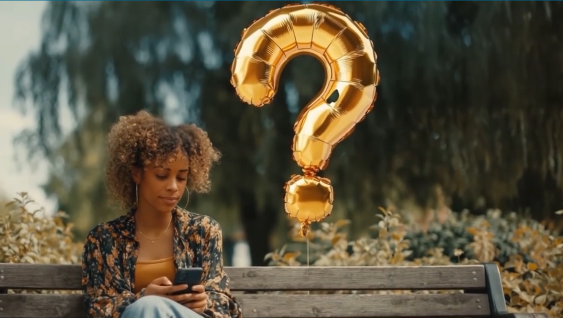 A woman sits on a park bench looking at her phone, with a large gold question mark balloon floating beside her. Trees and bushes are in the background.